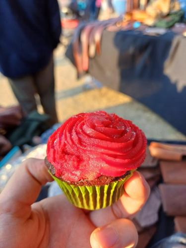 Hand holding a tempting red chili cupcake, a unique and spicy twist on a classic sweet treat